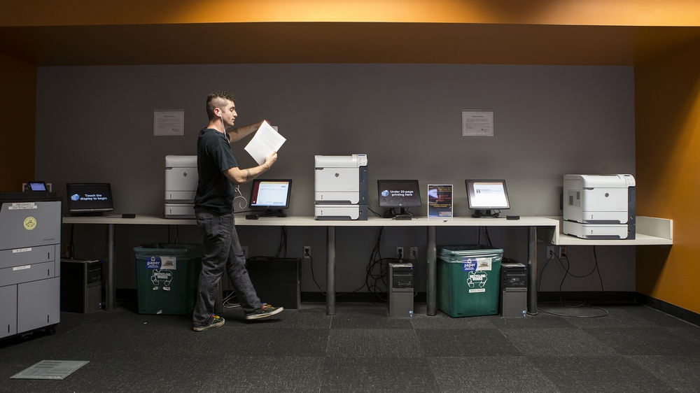 Student retrieving document from Print on the Go Print Station in the TECH Center