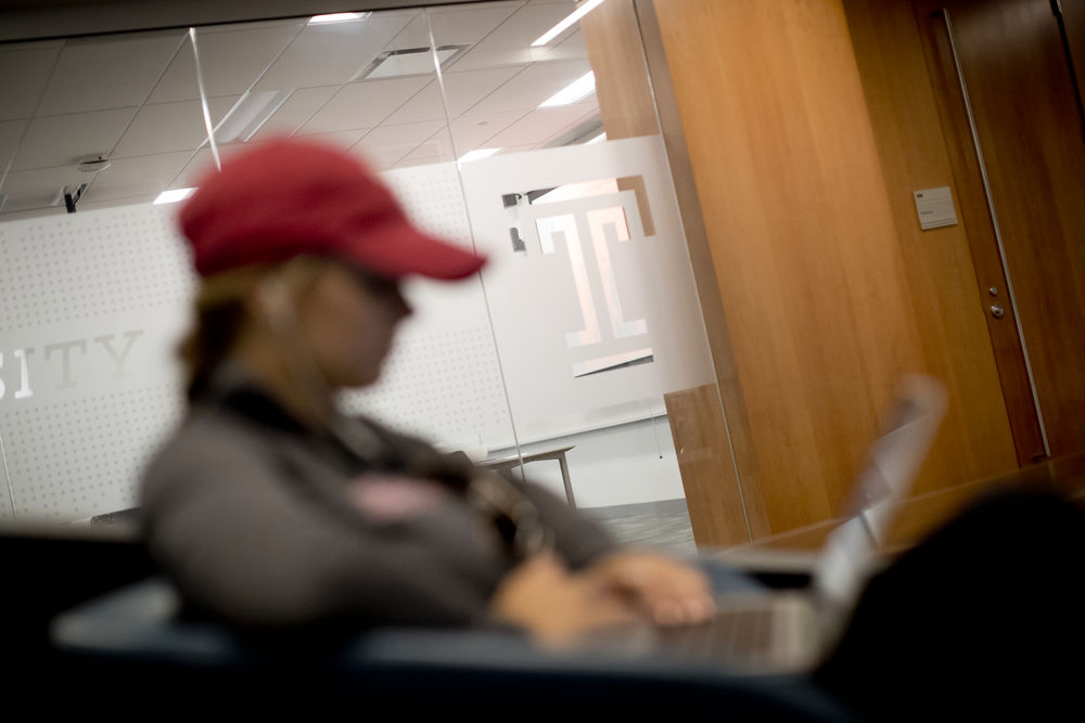 Student Looking at Laptop in Classroom Lounge Area
