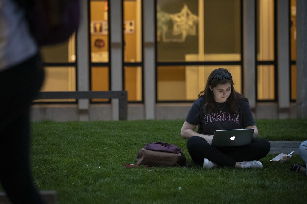 Student Using Laptop at Temple's Bell Tower